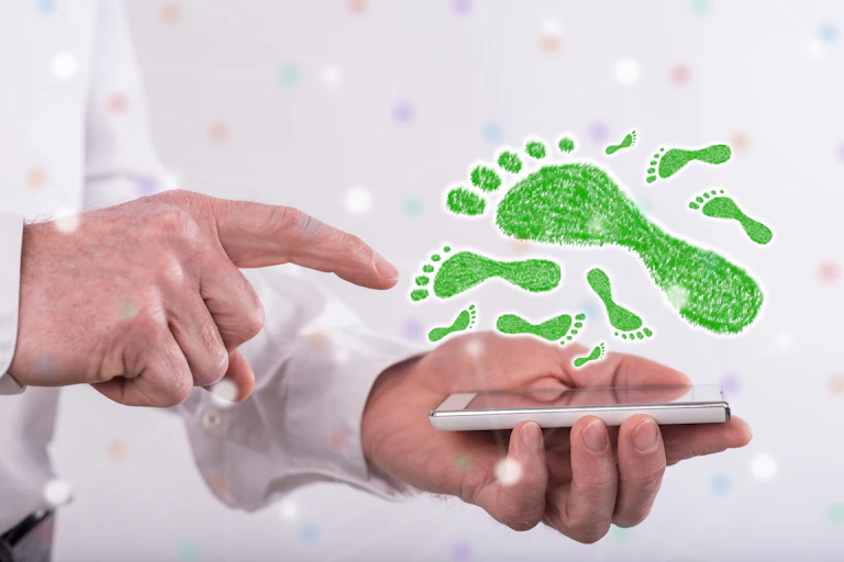 finger points to smart phone below green footprints
