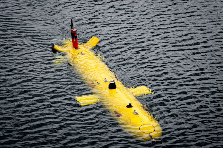 A bright yellow torpedo-shaped autonomous underwater vehicle