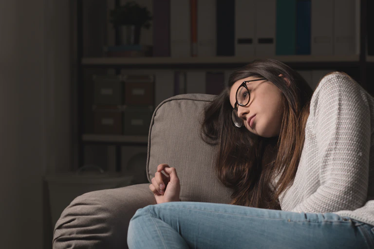 girl looks sad on couch