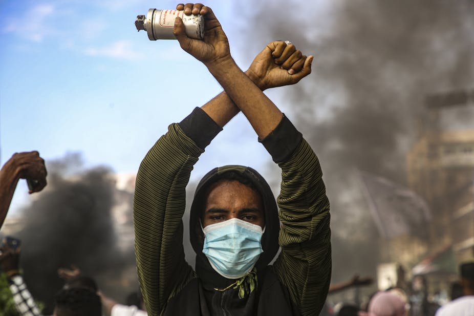 A Sudanese protestor holds up a tear gas cannister