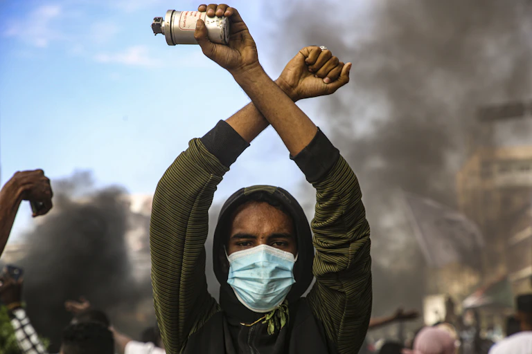 A Sudanese protestor holds up a tear gas cannister