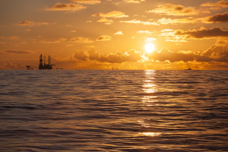 Oil rig on the horizon with sunset.