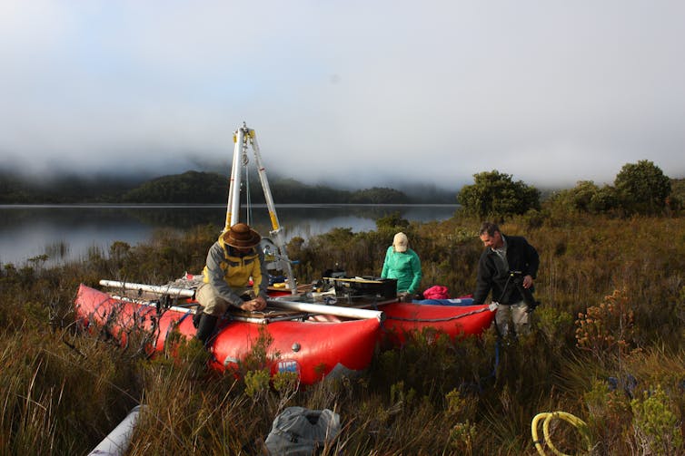 people on floatation device near lake