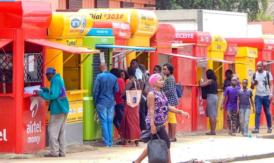 People standing infront of multi colored containers conducting business