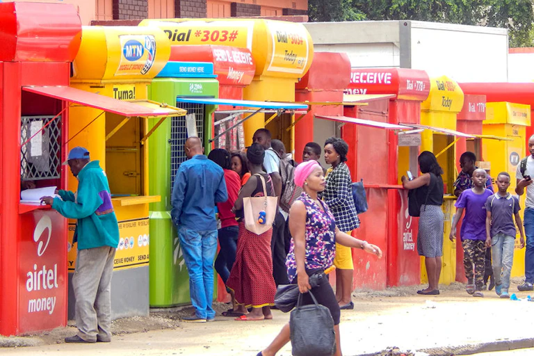 People standing infront of multi colored containers conducting business