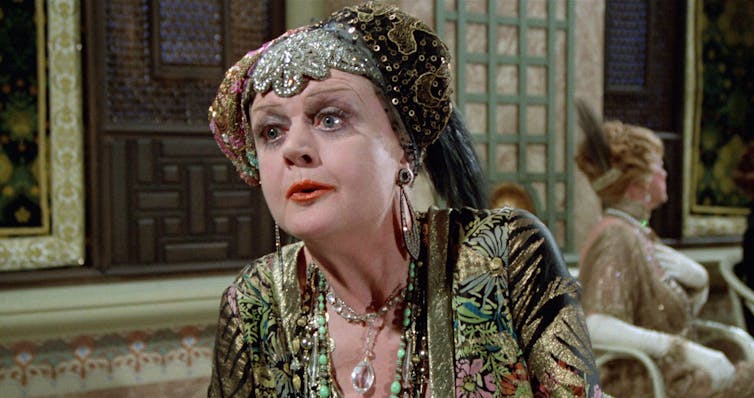 Woman in ornamental headress talks.