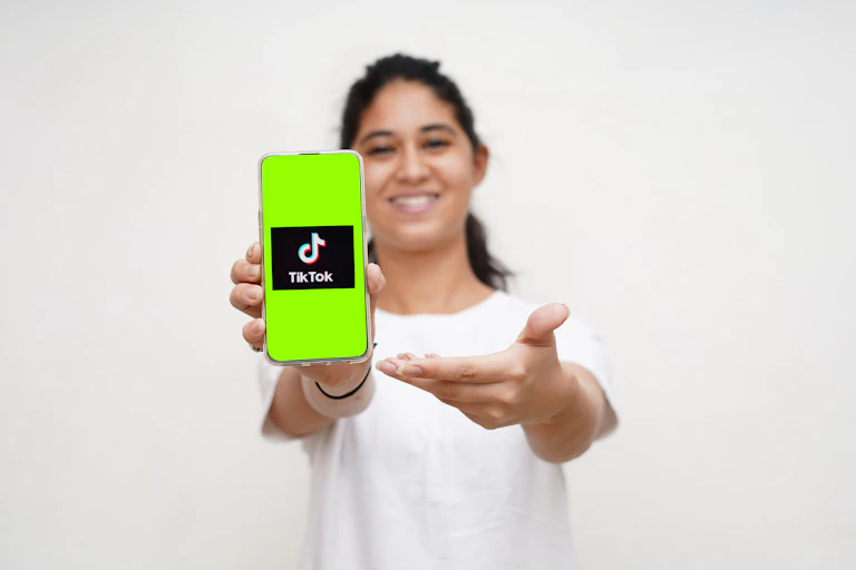 Girl holding up a phone with a TikTok icon