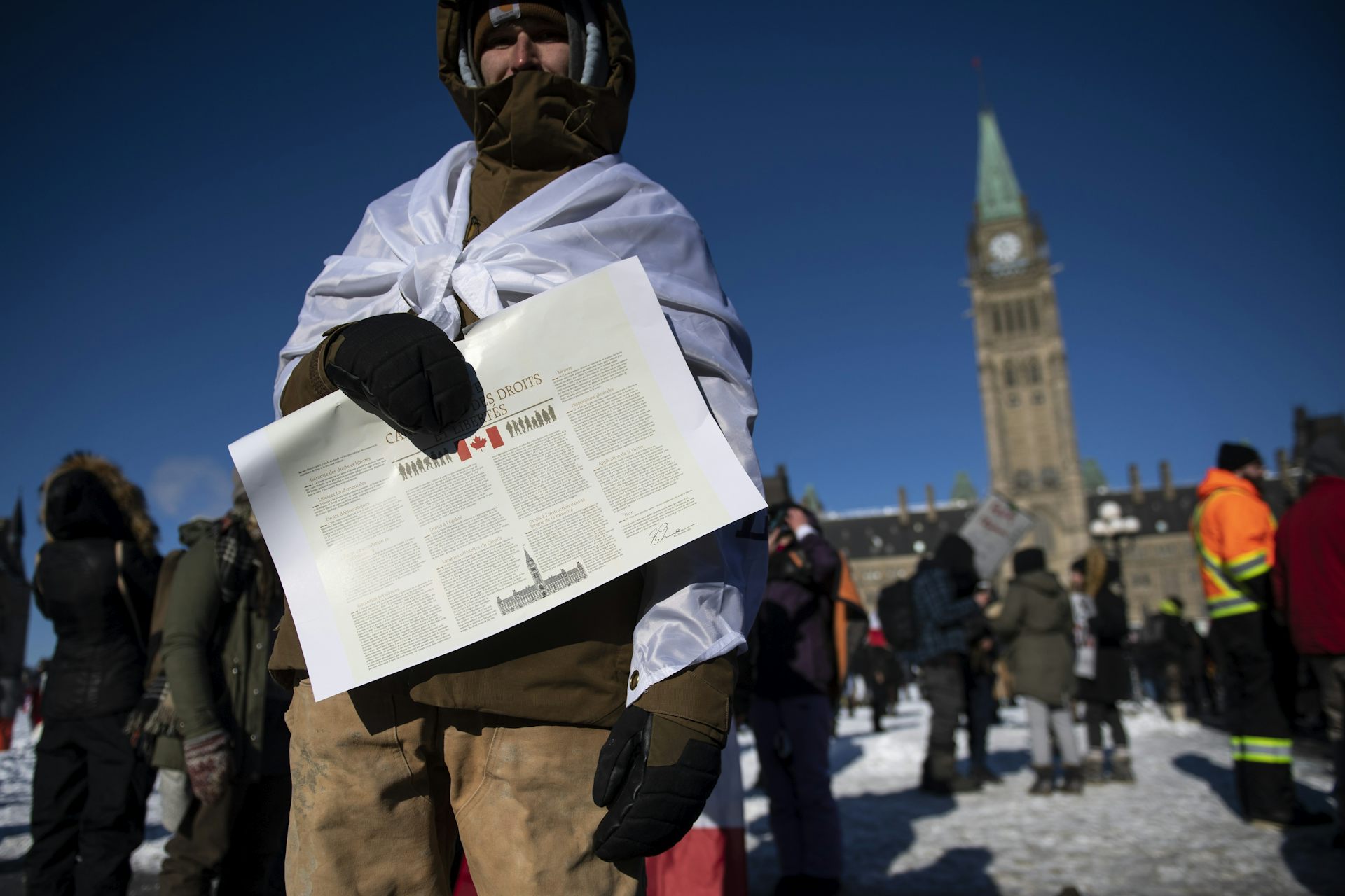 Un homme se tient devant le Parlement et tient un document