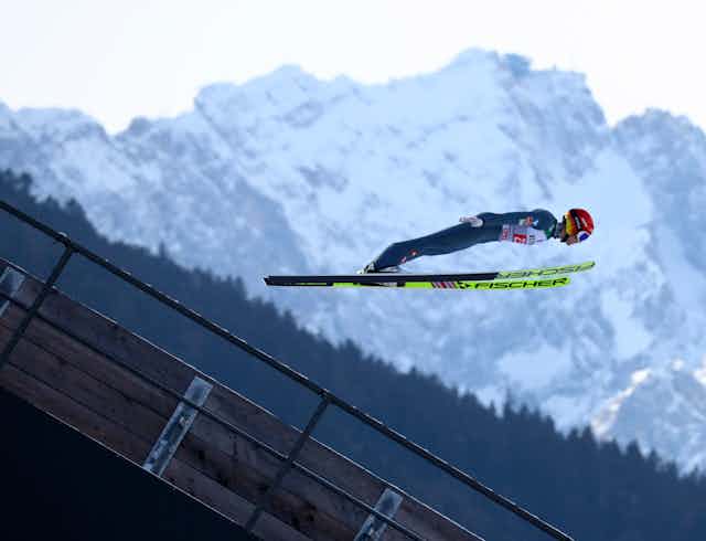 A ski jumper flying through the air.