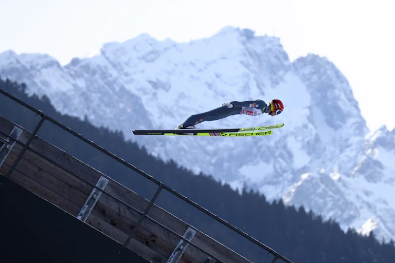 A ski jumper flying through the air.