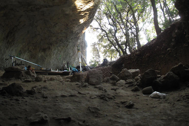 looking out from a cave, surveying equipment in foreground