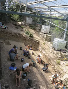 people kneeling on ground, working in the dirt