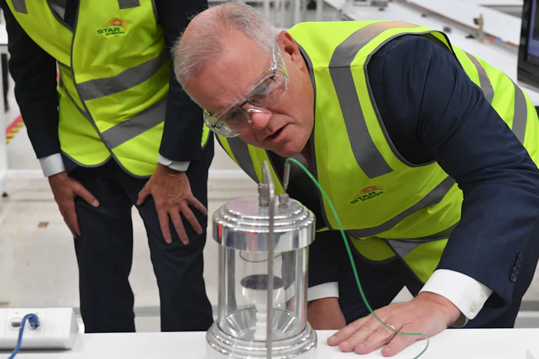 Man in high-vis vest peers at a scientific device