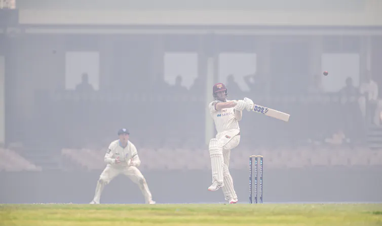 cricket players playing as bushfire smoke fills the ground