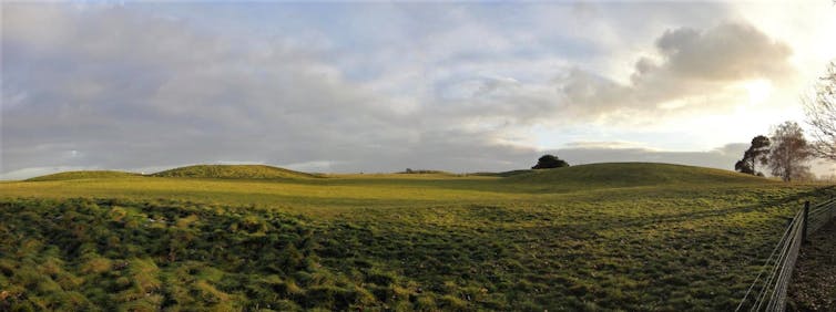 Landscape photograph showing burial mounds in grass
