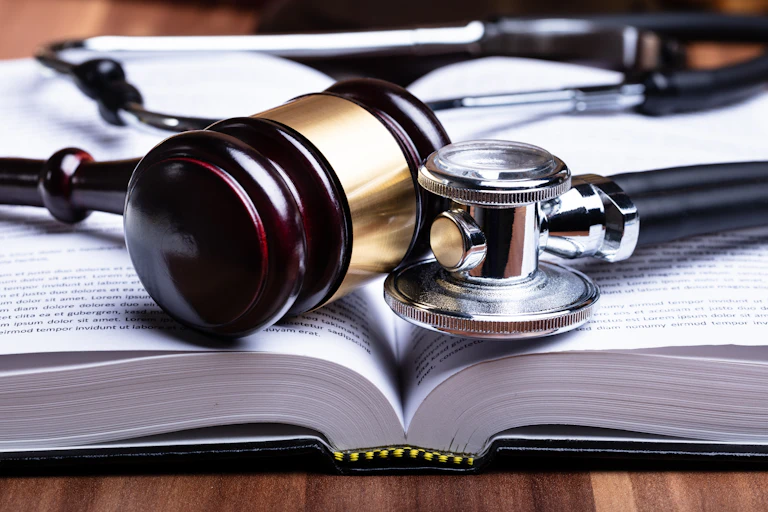 Close-up of a stethoscope and mallet over an open book.