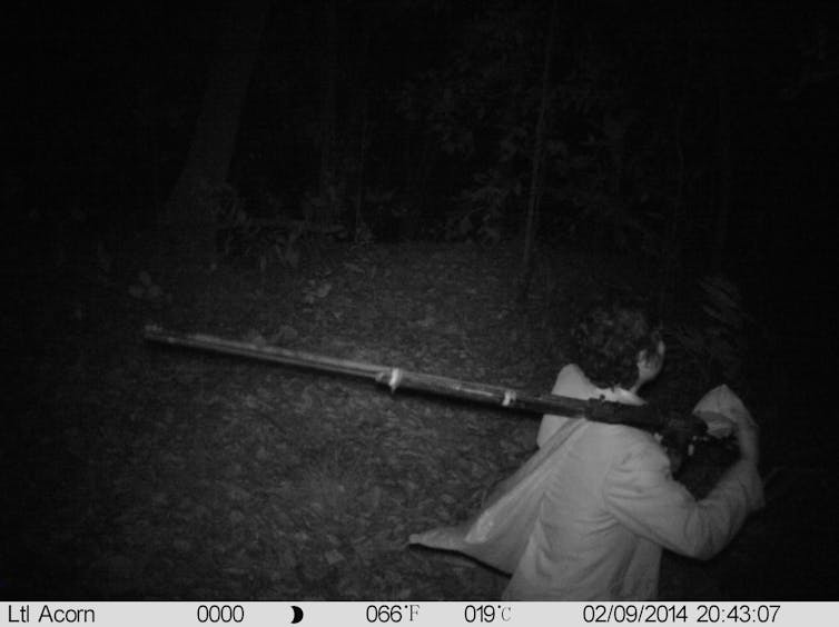 a night time camera capture of someone walking with a shotgun