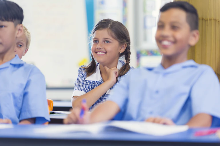 Children sit in a classromm.