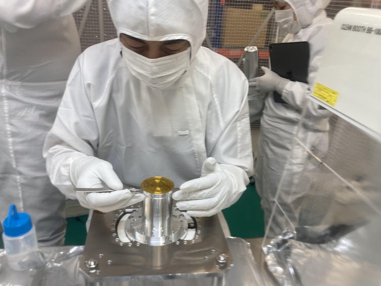 Scientists preparing the sample capsule for analysis. Trevor Ireland, Author provided