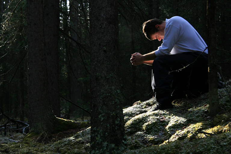 man in forest praying
