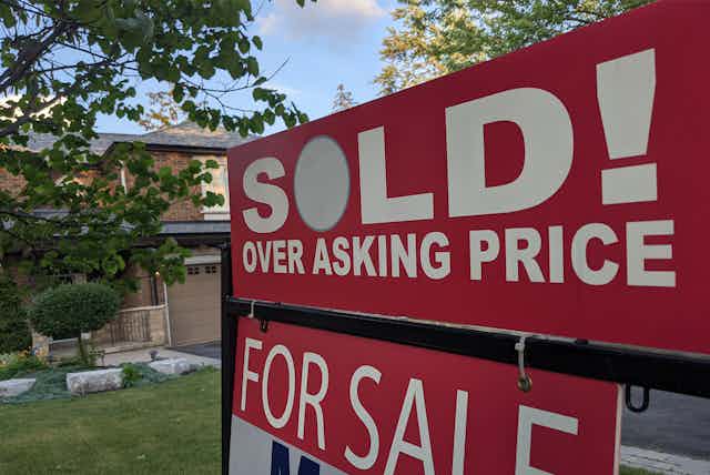 a sign in front of house SOLD! OVER ASKING PRICE