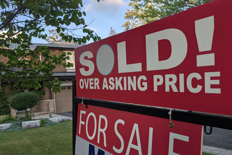 a sign in front of house SOLD! OVER ASKING PRICE