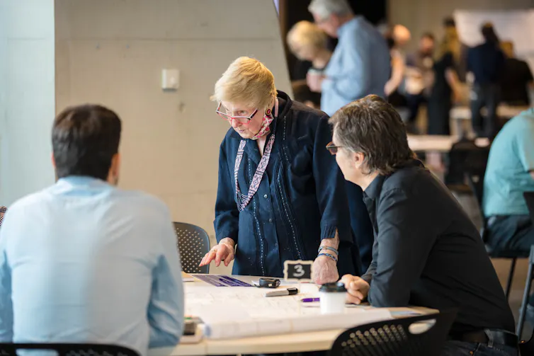 Woman standing at a table looking at drawings