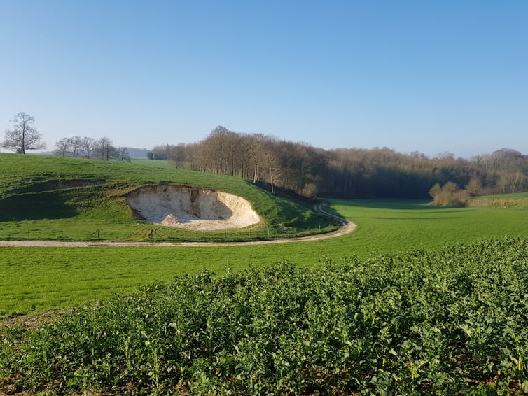 A hillside with a large, white crater in.