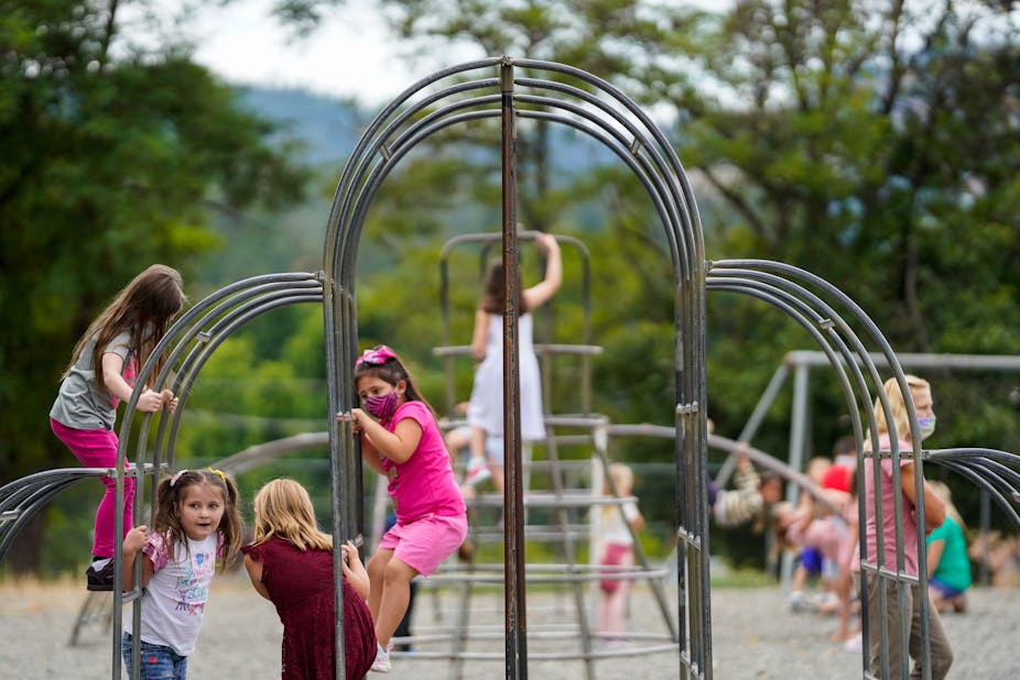 Children play on a playground structure