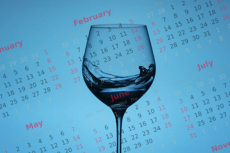 Wine glass against a calendar on a blue background