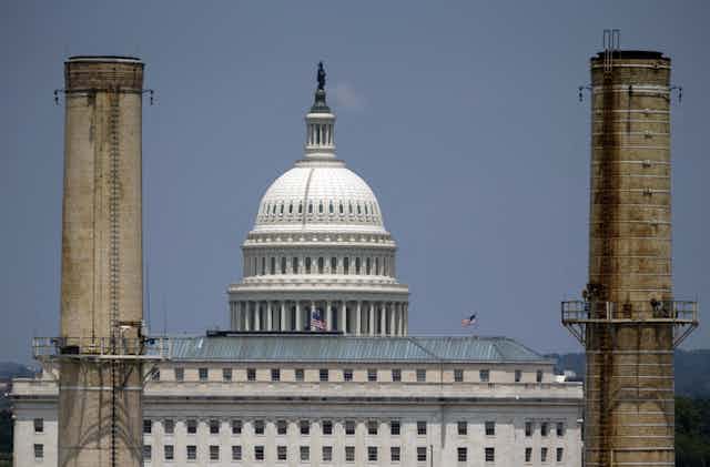 The U.S. Capitol seen through two power plant stacks.