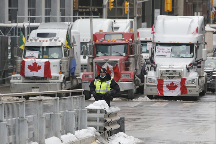 A row of three trucks blocking a street