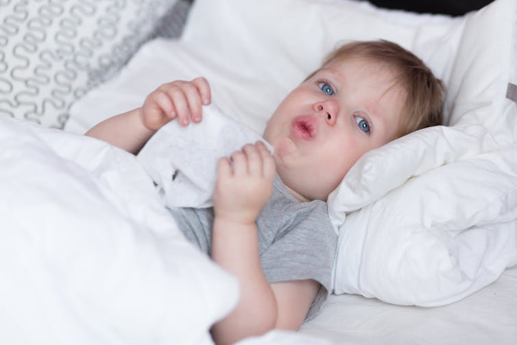 Baby in bed coughing
