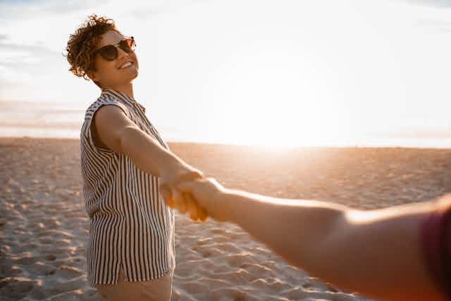 Women holding hands on a beach