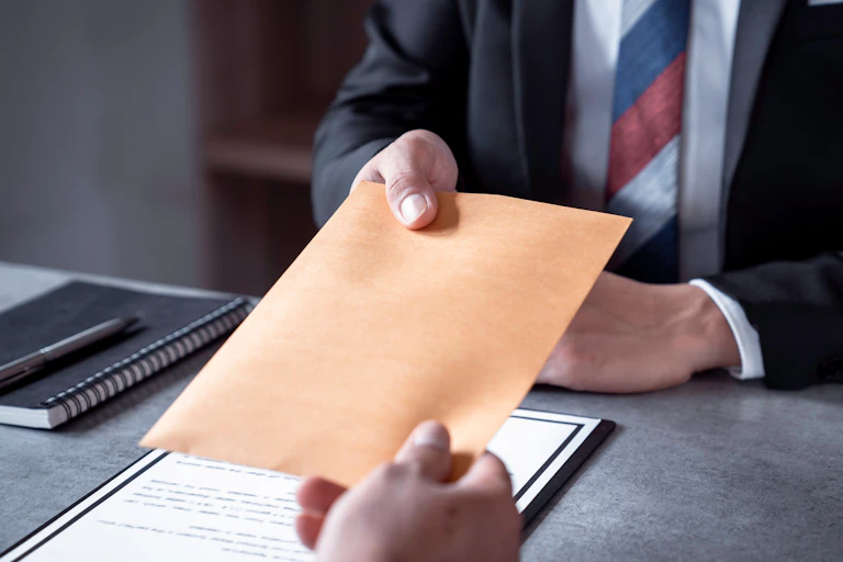 Handing over a plain envelope.