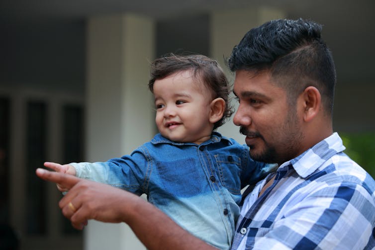 Father pointing with young son.