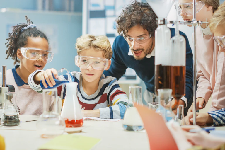 Alumnos y profesor haciendo experimentos químicos.