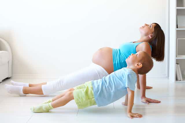 Mujer embarazada y niños haciendo ejercicio.