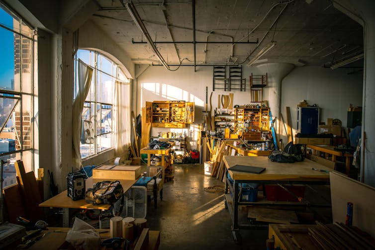 Sunlight streams into a workshop in an old warehouse.