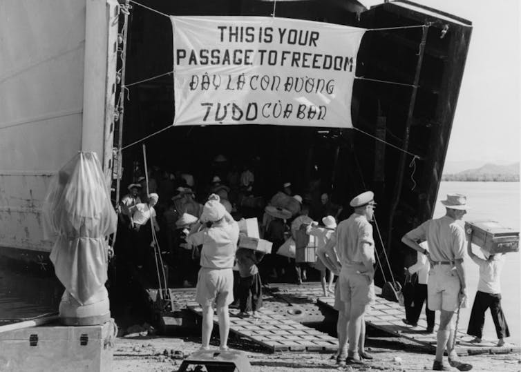 People are boarding a ship, a big banner reads 'this is your passage to freedom'