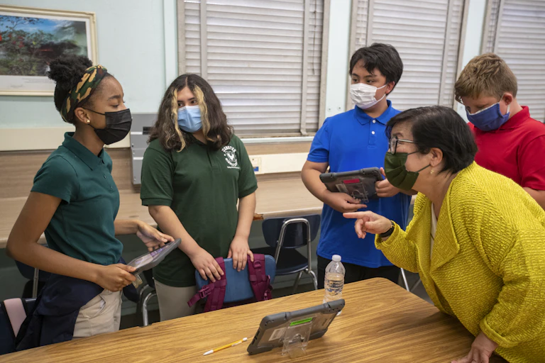 A teacher engages with a group of students in class.