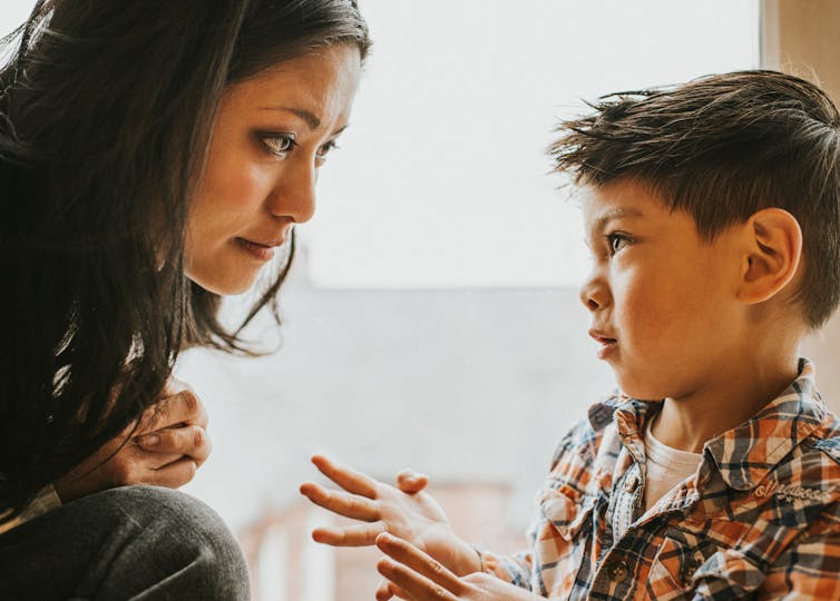 close-up of woman listening to young boy