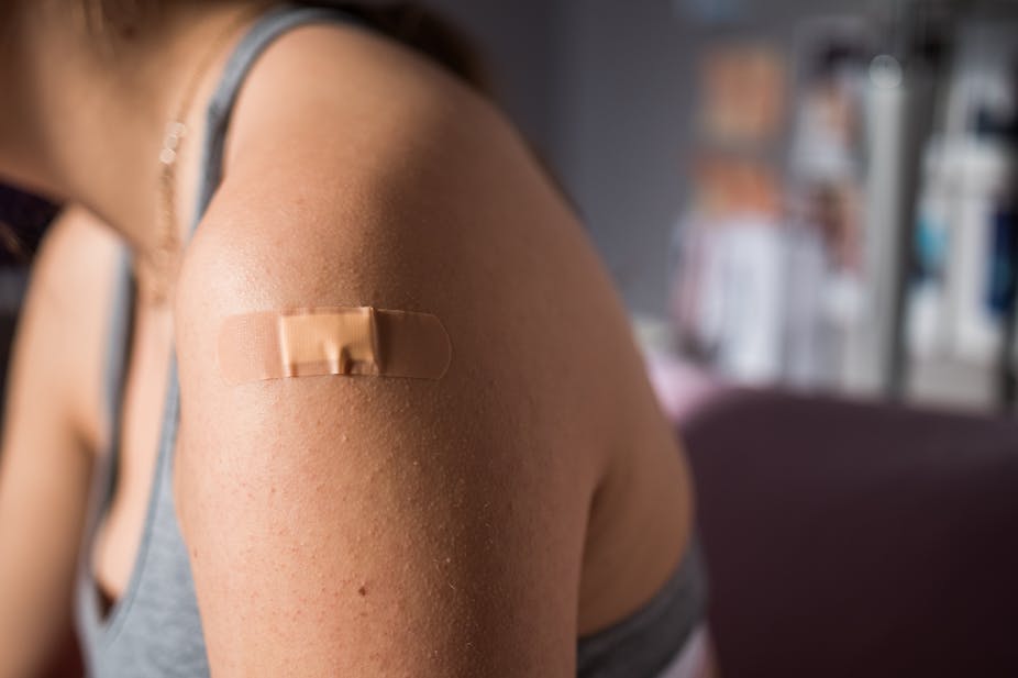 Woman's arm with a bandaid, after being vaccinated.