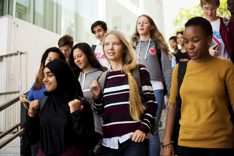 Diverse teenagers walking down school stairs