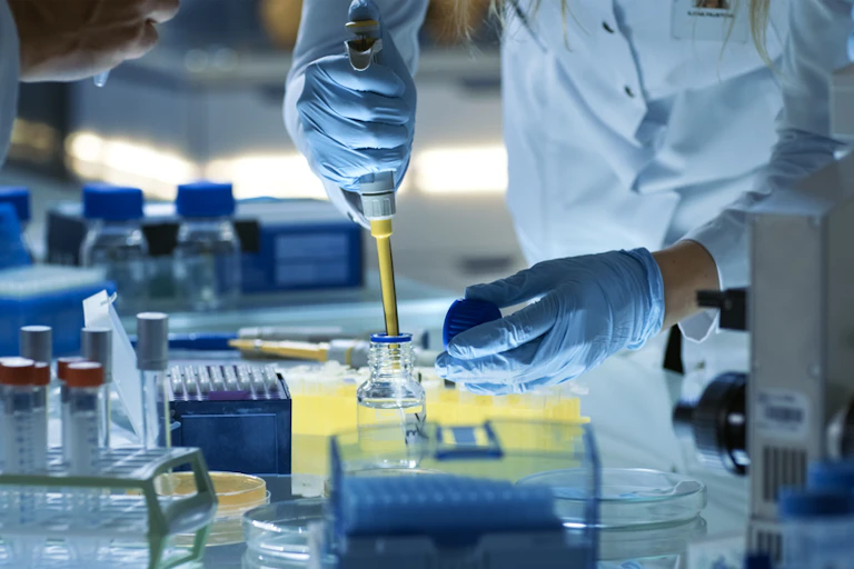 A scientist pipetting in a lab