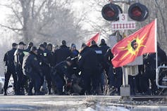 Police swarm protesters near a railway crossing
