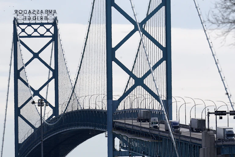 Trucks drive across a suspension bridge.