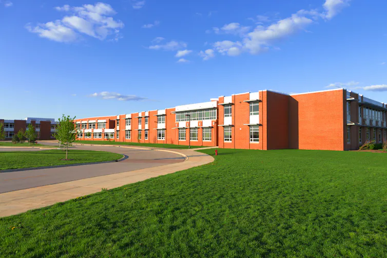 A school seen behind a green lawn.