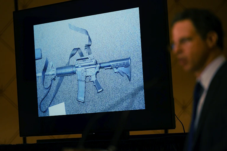 An image of the weapon used during the Newtown shooting is displayed while an attorney speaks during a news conference.
