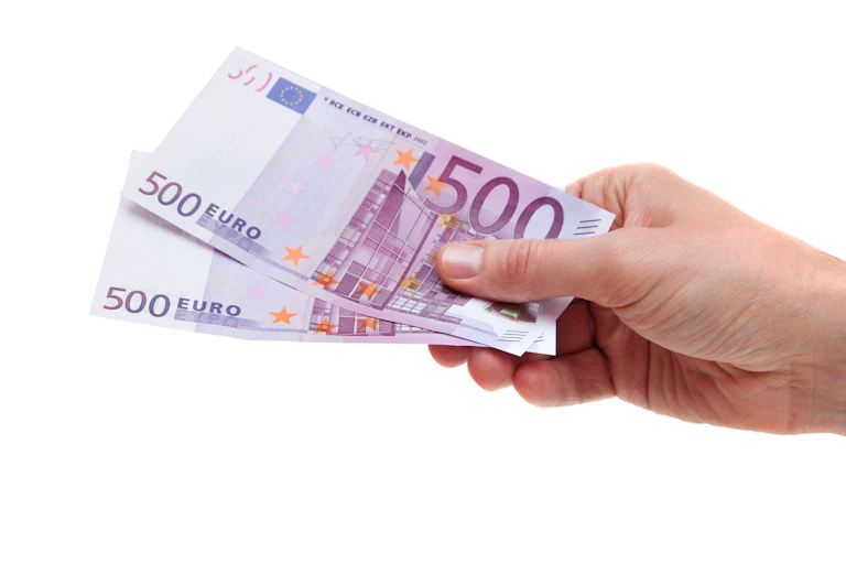Una mano con dos billetes de 500 euros.